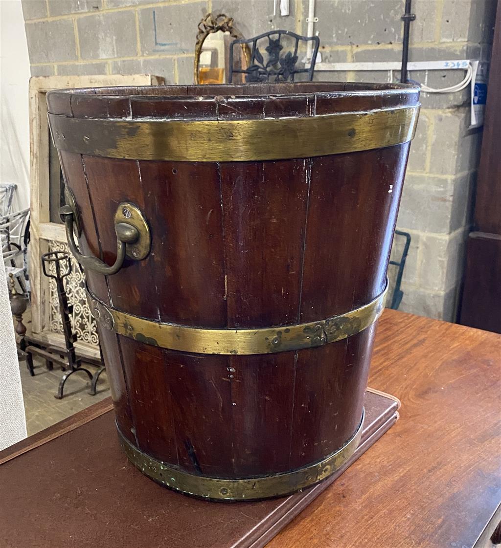 A George III circular brass bound mahogany peat bucket, fitted with two carrying handles, diameter 35.6cm, height 41cm